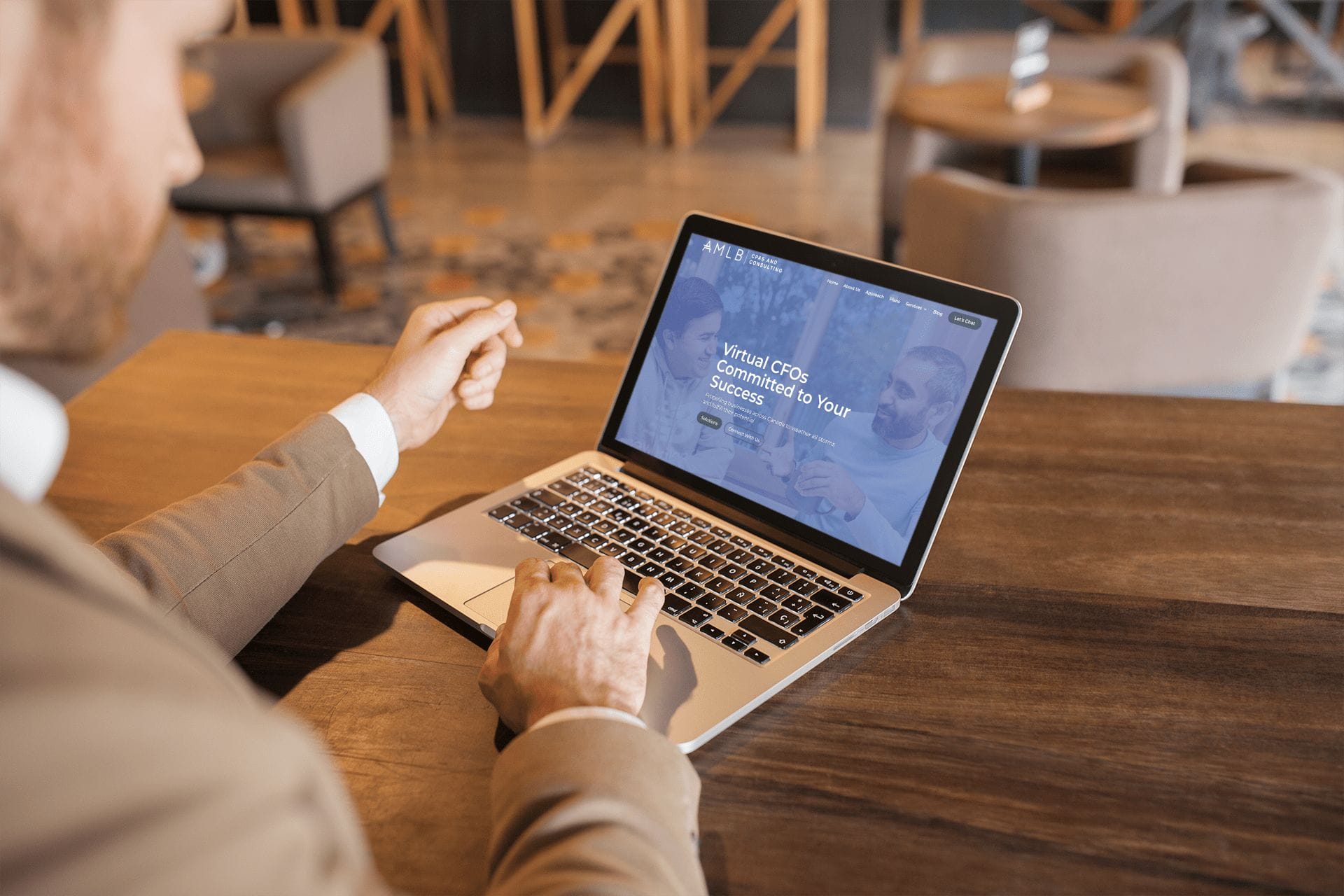 Businessman using AMLB website on laptop.