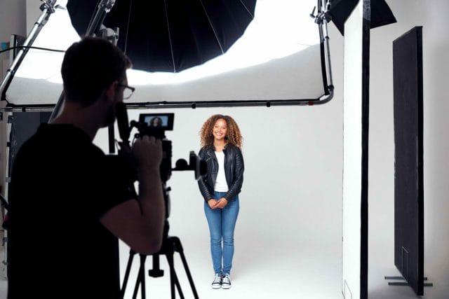 Female model working on set at studio, white backing.