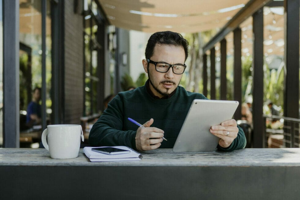 Portrait of business owner surfing social media on tablet.