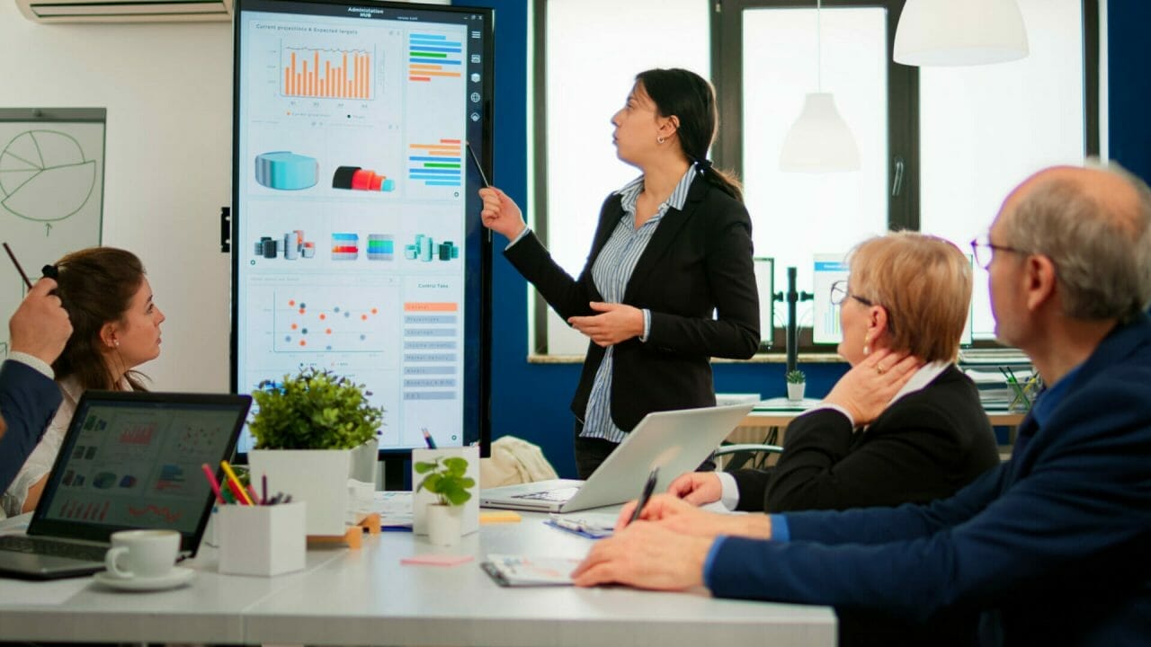 Portrait of female manager presenting slideshow to business colleagues.