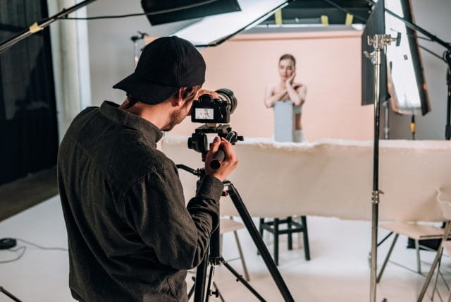 Cameraman filming a model.